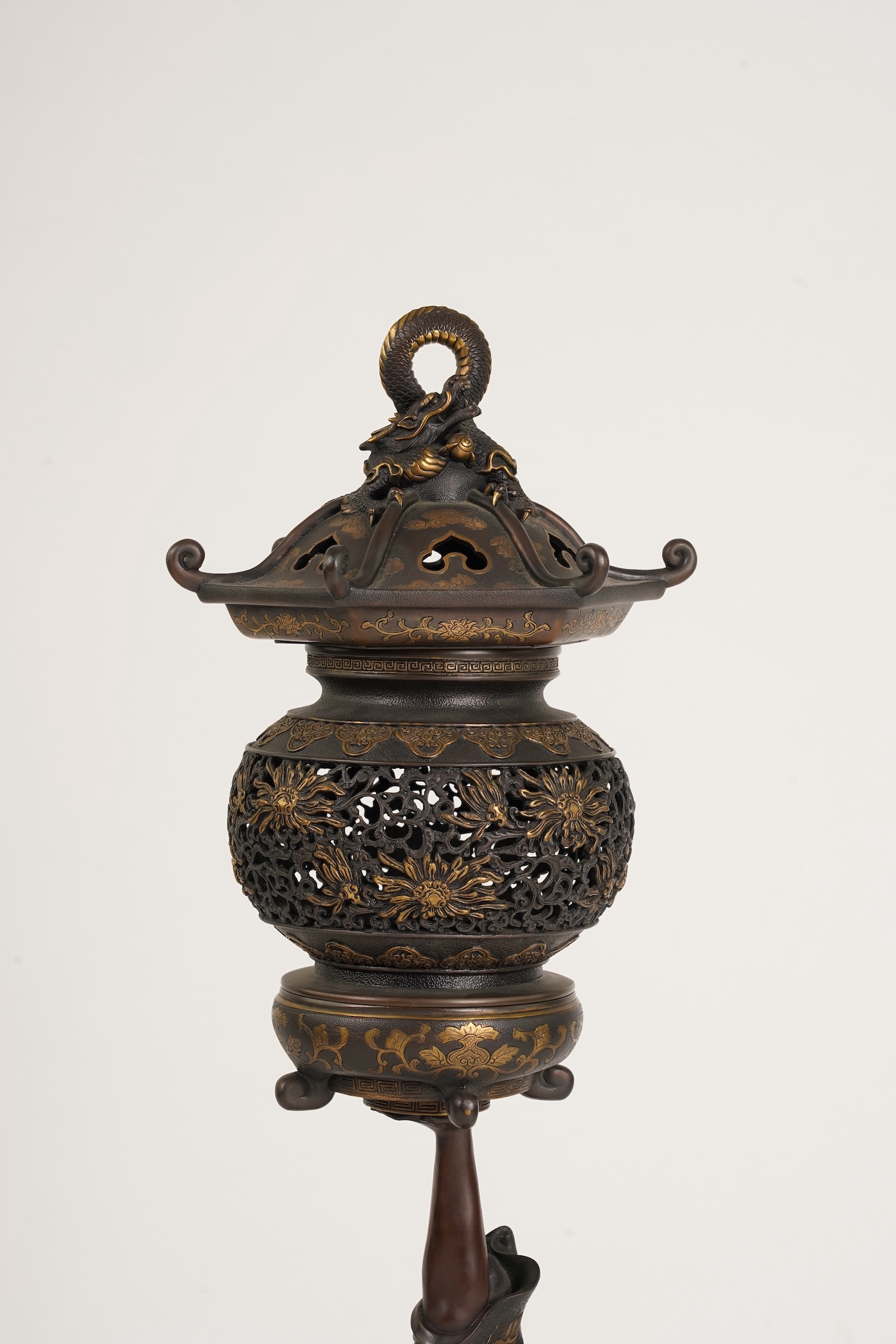 A large Japanese Miyao style parcel gilt bronze figure holding a koro aloft, 20th century
